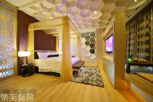 a bedroom with a bed and a tv in a room at Doule Motel in Taichung