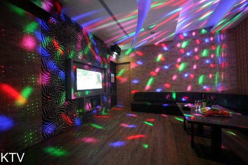 a room with a tv and a wall with colorful lights at Doule Motel in Taichung