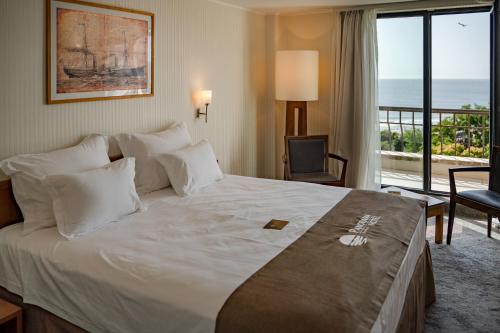 a hotel room with a bed with a view of the ocean at Panorama Hotel - Free EV Charging Station in Varna City