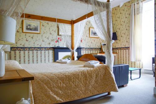 - une chambre avec un lit à baldaquin dans l'établissement Abbey Grange Hotel, à Llangollen
