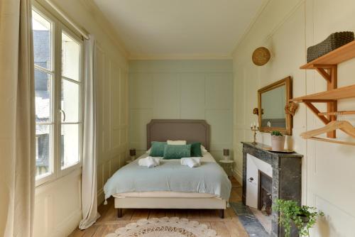une chambre avec un lit et une cheminée dans l'établissement La Suite de Pauline - Appt au coeur de Rennes, à Rennes