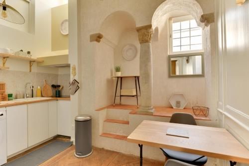 une cuisine avec une table et des chaises et une fenêtre dans l'établissement La Suite de Pauline - Appt au coeur de Rennes, à Rennes