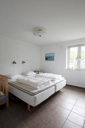 a white bedroom with a large bed in it at Villa M in Simrishamn