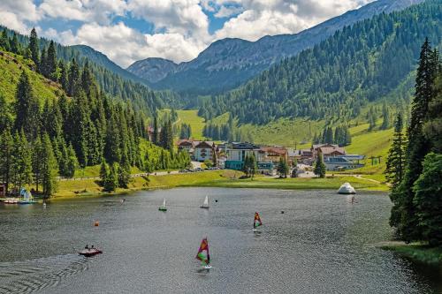 a group of boats on a lake in the mountains at Hotel Sportwelt in Zauchensee