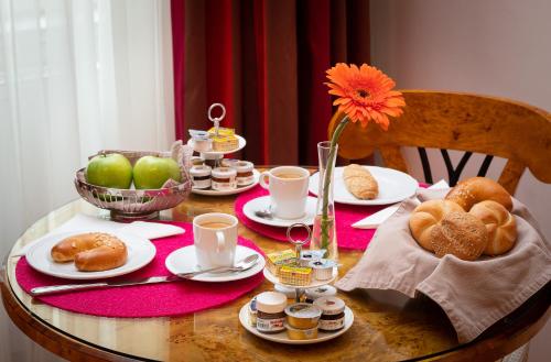 a table with plates of food and a flower on it at Appartement-Hotel an der Riemergasse in Vienna