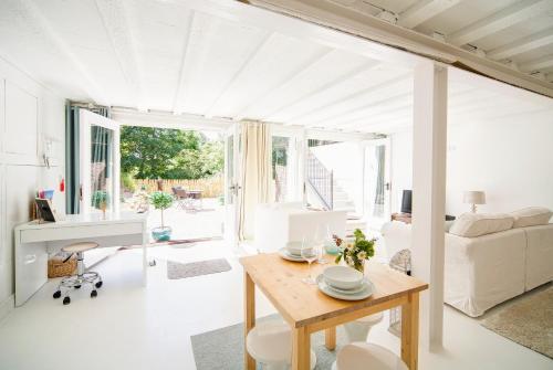 The Retreat Studio في كارلايل: غرفة معيشة بيضاء مع طاولة وأريكة