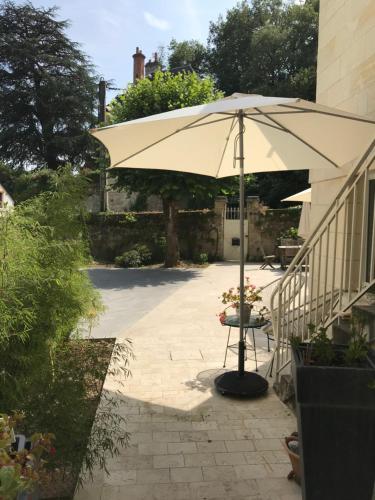 um guarda-chuva sentado num pátio ao lado de uma escada em Chambre Troglodytique Villa Marie Louise em Rochecorbon