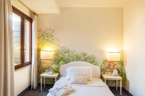 a bedroom with a white bed and two tables at Albergo Al Moretto in Castelfranco Veneto