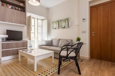 sala de estar con sofá, mesa y silla en T2, Tirso de Molina, apartamento luminoso y tranquilo, en Sevilla