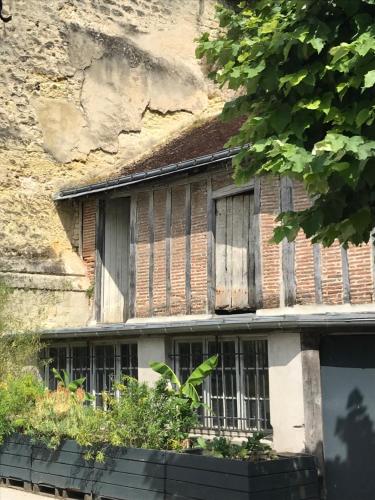 an old brick building with windows and plants at Chambre Troglodytique Villa Marie Louise in Rochecorbon