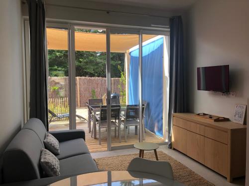 Le Grand VieilにあるLes Gîtes de la Clereのソファとガラスの引き戸のあるリビングルーム