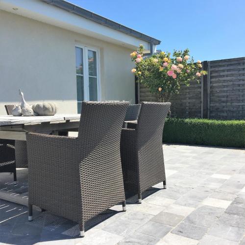 two chairs and a table on a patio at Charmehotel Kruishof in Ostend