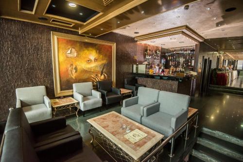 a bar with chairs and a painting on the wall at Prezident Hotel in Novi Sad
