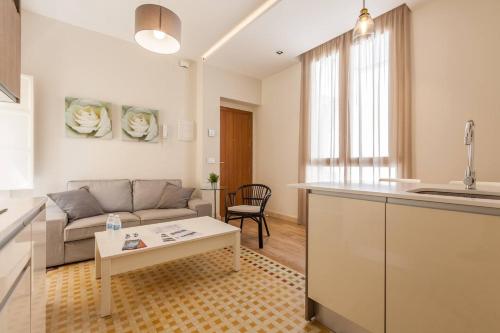cocina y sala de estar con sofá y mesa en T2, Tirso de Molina, apartamento luminoso y tranquilo, en Sevilla
