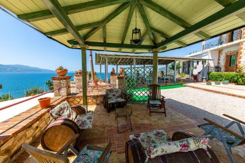 an outdoor patio with chairs and a view of the ocean at Hotel "SAN SAENA " in Vlorë
