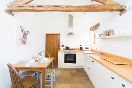 a kitchen with a wooden table and a dining room at The Nook Cottage in Carlisle