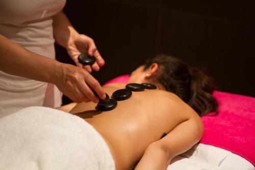 a woman getting a massage from a woman laying on a bed at Golden Costa Salou - Adults Only 4* Sup in Salou
