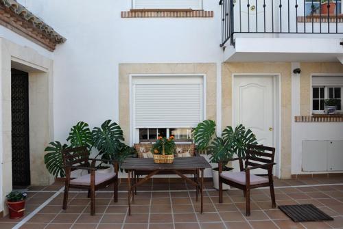 patio con mesa, 2 sillas y ventana en Apartamentos Jerezanos, en Jerez de la Frontera