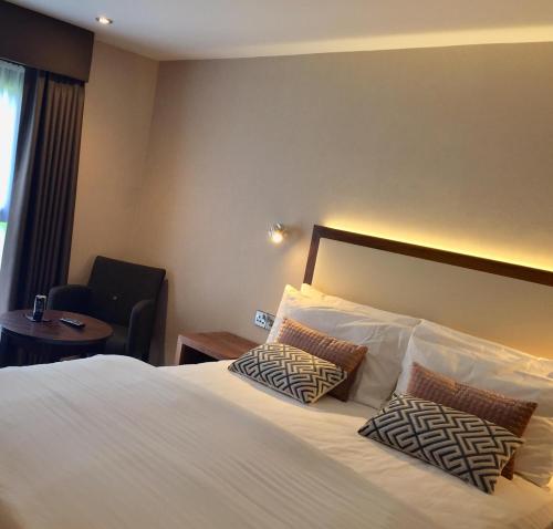 a hotel room with a bed with two pillows at Best Western Appleby Park Hotel in Tamworth
