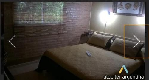 1 dormitorio con 1 cama con luz encendida en Cabañas Thijada en Mina Clavero