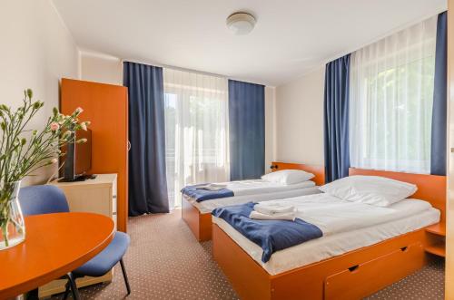 ブワディスワボボにあるVilla Dominikのベッド2台とテーブルが備わるホテルルームです。