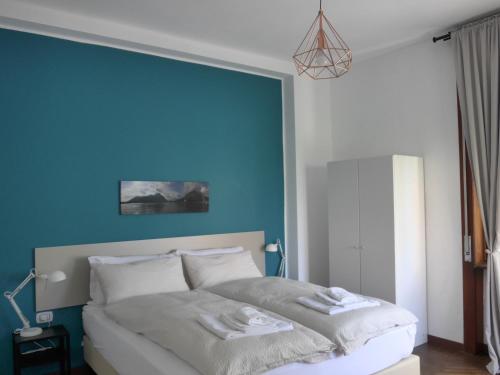 a bedroom with a bed with a blue wall at La Tana Rooms in Lenno