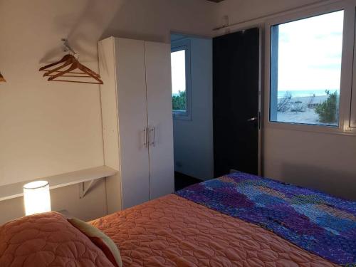 a bedroom with a bed and a window at Medanos in Las Gaviotas