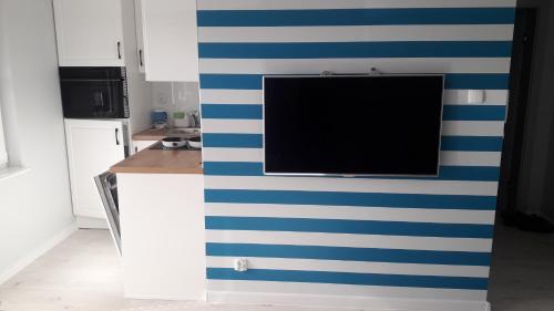 a kitchen with a blue and white striped wall at Apartament Nadmorski LUX1 in Sztutowo