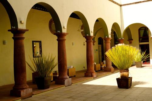 a building with columns and potted plants in a courtyard at Hotel La Morada in San Miguel de Allende