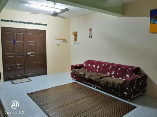 a couch sitting in a room with a door at BB HOMESTAY in Kampung Tualang