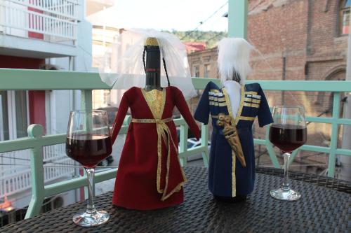 two mannequins in medieval clothing and wine glasses on a table at Hotel Tbiliseli in Tbilisi City