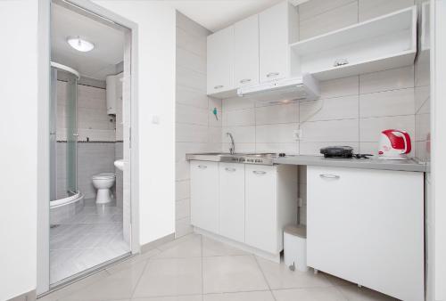 cocina blanca con lavabo y aseo en Apartments Villa Popovic, en Kotor