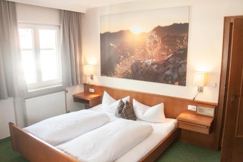 a bedroom with two beds and a painting on the wall at Pension Gletscherblick in Fulpmes