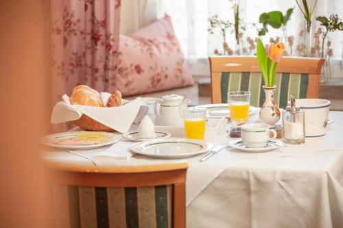 a table with a breakfast of bread and orange juice at Pension Gletscherblick in Fulpmes