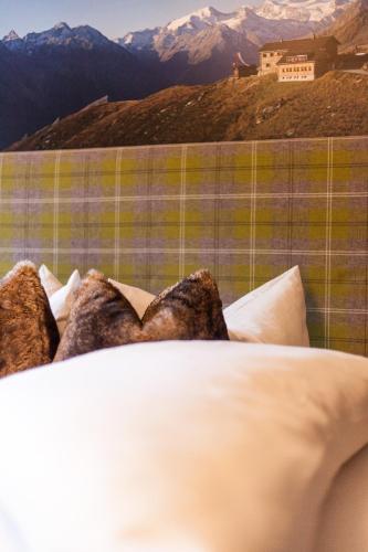 a bed with pillows on it with mountains in the background at Pension Gletscherblick in Fulpmes