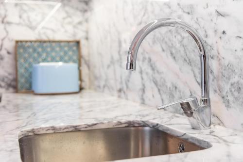 a kitchen sink with a faucet on a counter at Porto Belo Sao Bento Apartment in Porto