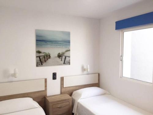- une chambre avec 2 lits et une photo de la plage dans l'établissement Duplex Playa del Cura beautiful ocean view, à Mogán