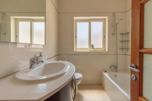 a bathroom with a sink and a toilet and a tub at Valletta Penthouse in Valletta