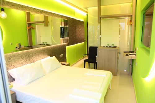 a bedroom with a white bed and a green wall at Oneiro Suites in Souda