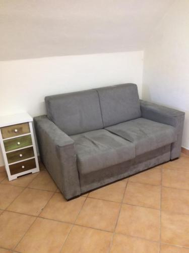 a gray couch in a living room with a table at Il Giramondo in Busca