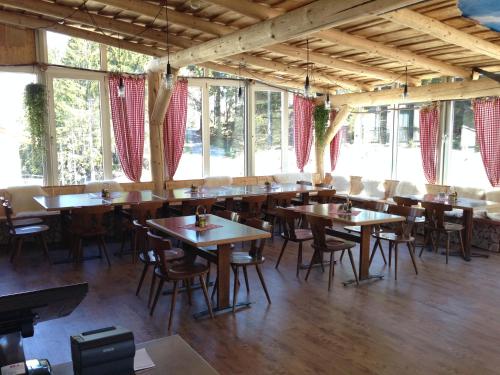 a restaurant with wooden tables and chairs and windows at ALTE SEKTION und Alpenblick in Flums