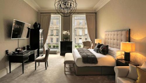1 dormitorio con cama, escritorio y ventana en Nira Caledonia, en Edimburgo