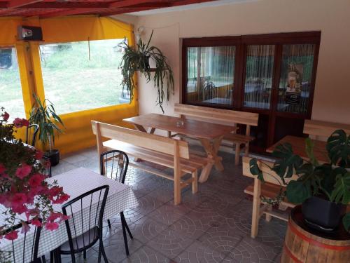 a room with tables and chairs and a table and benches at Prenoćište Vitas in Miljevina