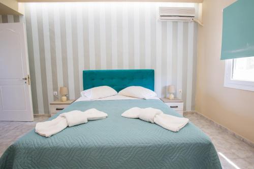 a bedroom with a bed with two towels on it at Laura Beach House in Alykes