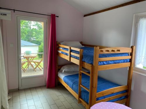 a bedroom with two bunk beds and a balcony at Auberge du Mont Tortue in Champclause