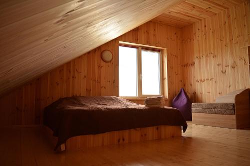 a bedroom with a bed in a room with a window at Gamtos apsupty in Palanga