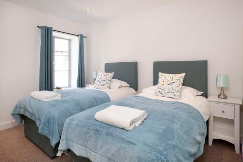 a bedroom with two beds with blue and white sheets at Almanna, Central York, only 6 minutes walk to York Minster in York