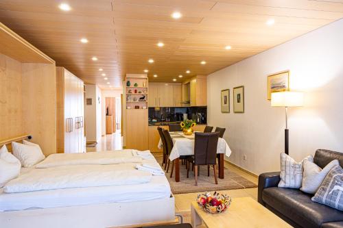 a bedroom with a bed and a dining room at Laax Rancho Family Apartment in Laax