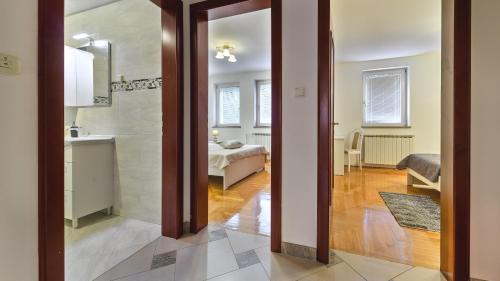 um corredor com casa de banho e uma cama num quarto em Central Apartment Smiley - FREE PARKING em Zagreb