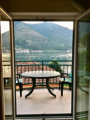 a table on a balcony with a view of the ocean at Apartment Balsa i Mia in Kotor